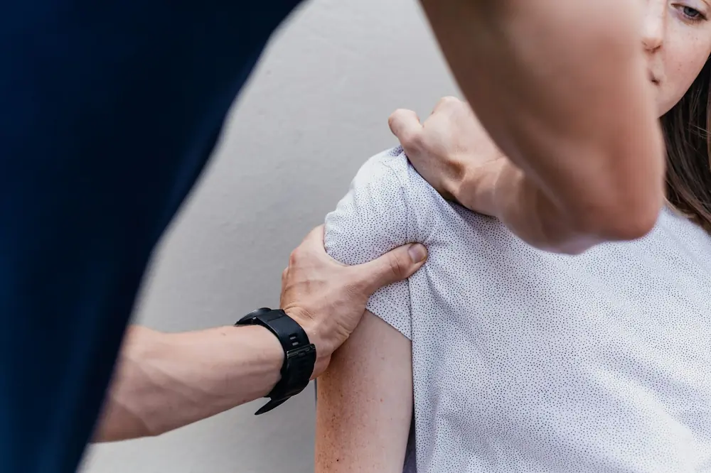 Fizjoterapeuta prowadzi terapię barku pacjentki